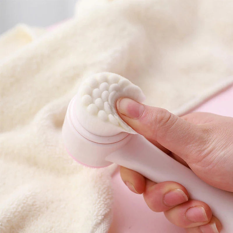 Person holding a white silicone scrubber against a soft pink fabric background
