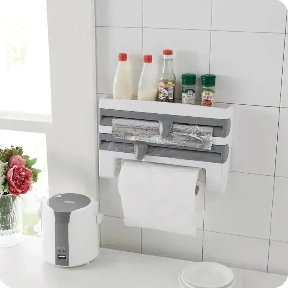 Wall-mounted kitchen organizer with paper towel holder, plastic wrap dispenser, and spice rack on a tiled wall.