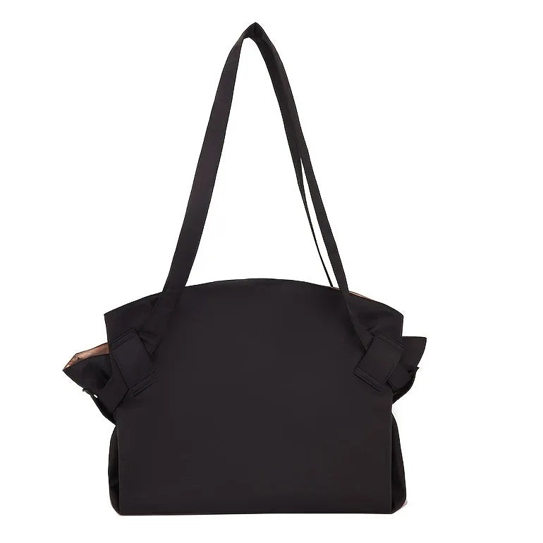 Black shoulder bag with ruffled details on a white background