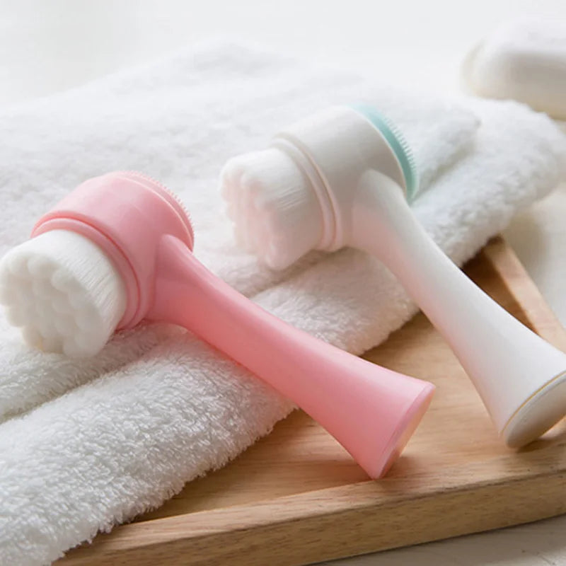 Pink and white exfoliating tools on a wooden surface with white towels.
