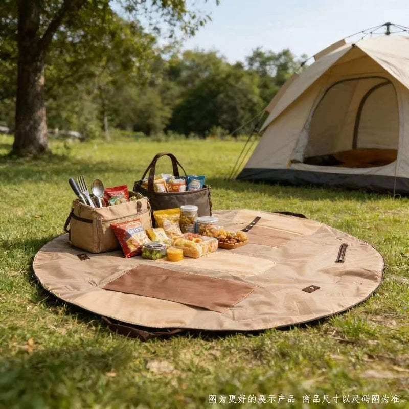 Camping scene with a tent, picnic blanket, and food items in a park.